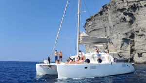 Luxury catamaran on a private boat tour in Santorini sailing across the caldera